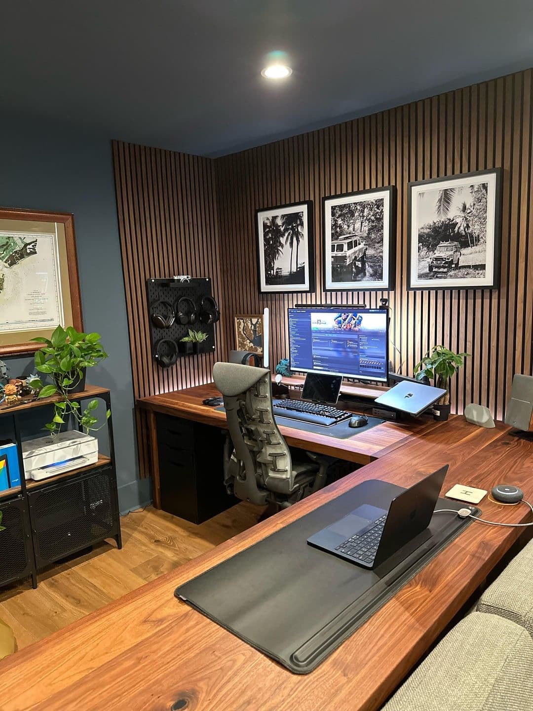 Home office corporativo com bancada amadeirada escura em L, ripado iluminado e setup duplo — Prime Line, Funcionários, Belo Horizonte
