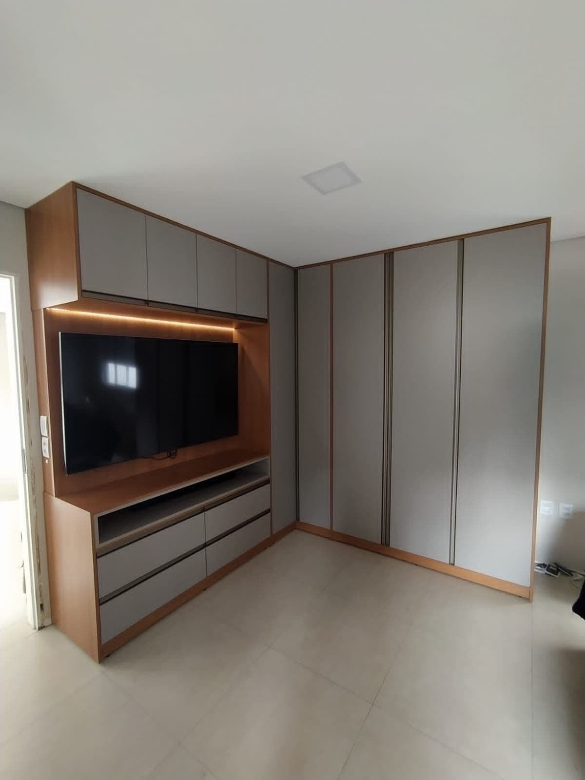 Dormitório com Painel TV Amadeirado e Guarda-roupa Cinza — Prime Line Ambientes Planejados, Belo Horizonte